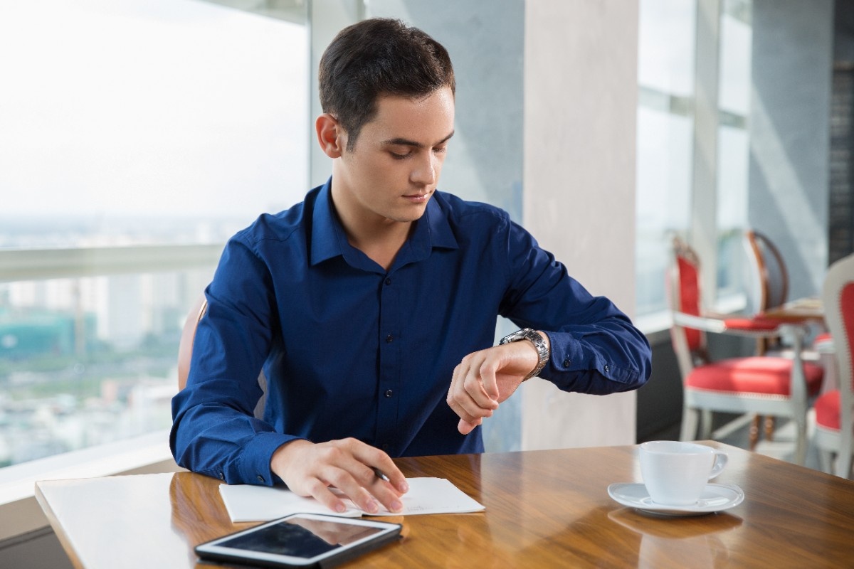 serious-young-businessman-looking-wrist-watch (1)